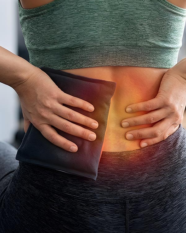 Back pain woman holding cooling ice pack on lower spine injury f inflammation on lower back