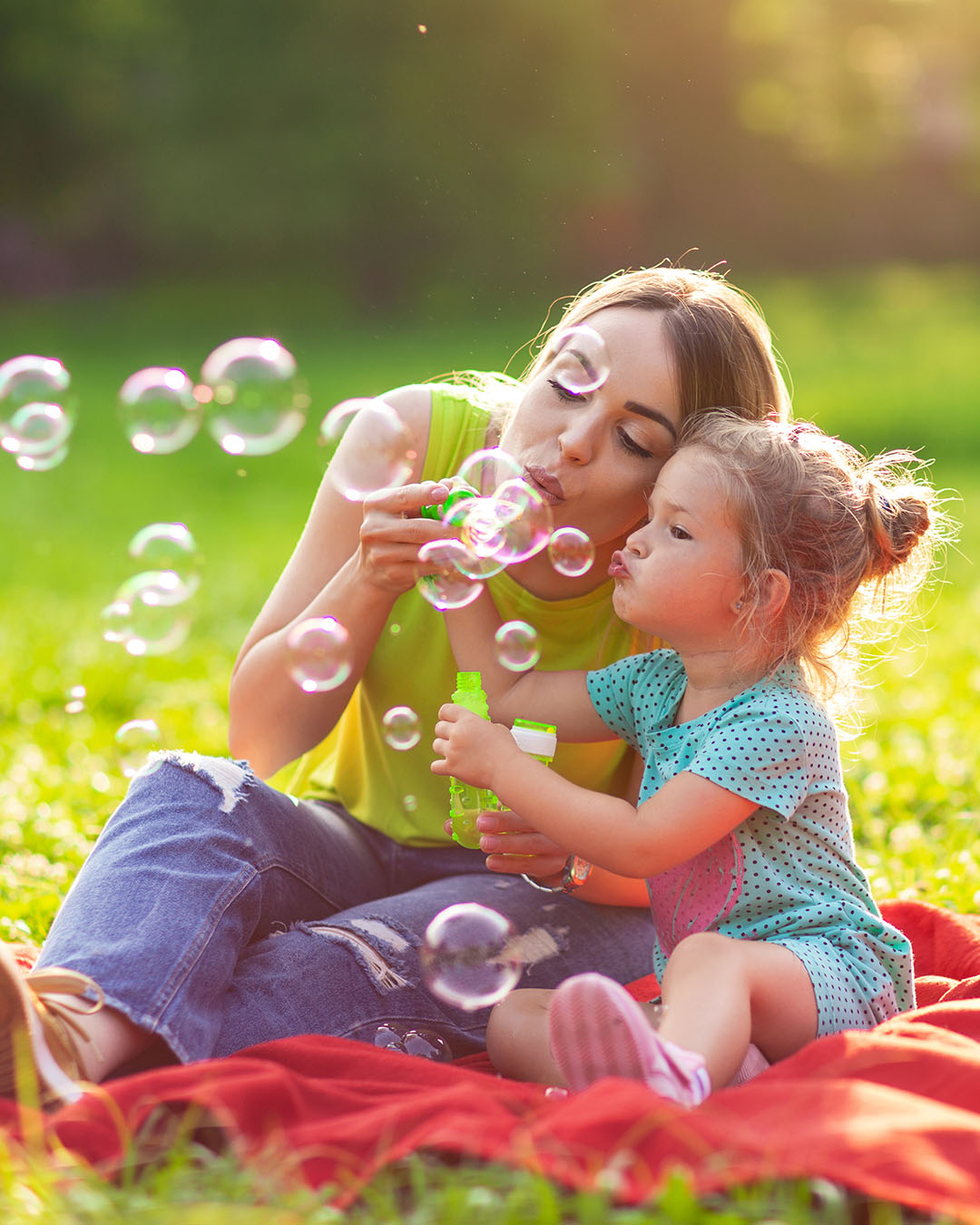 Family in park -Female child blows soup foam and make bubbles wi what moms need to know about chiropractic care
